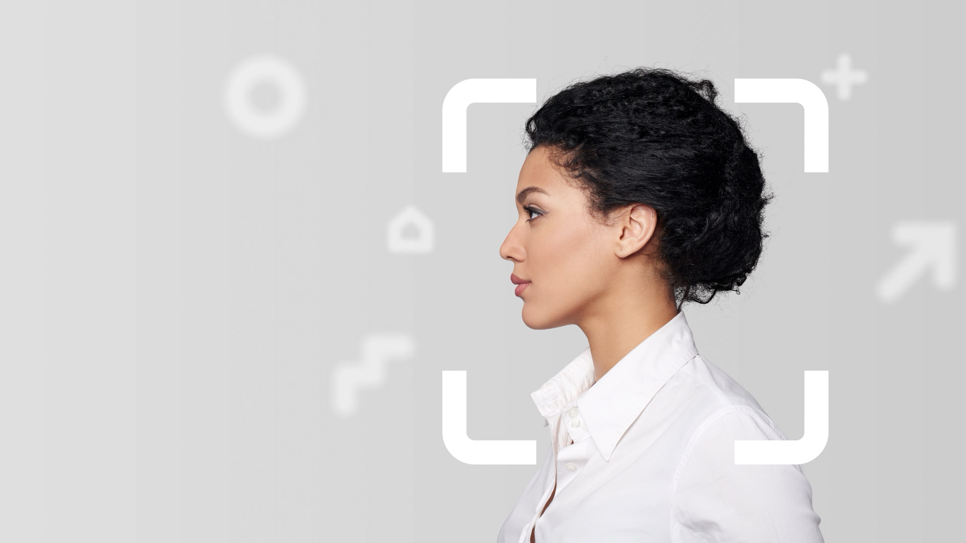 Young female professional Side profile of young woman with black hair in a bun wearing white shirt