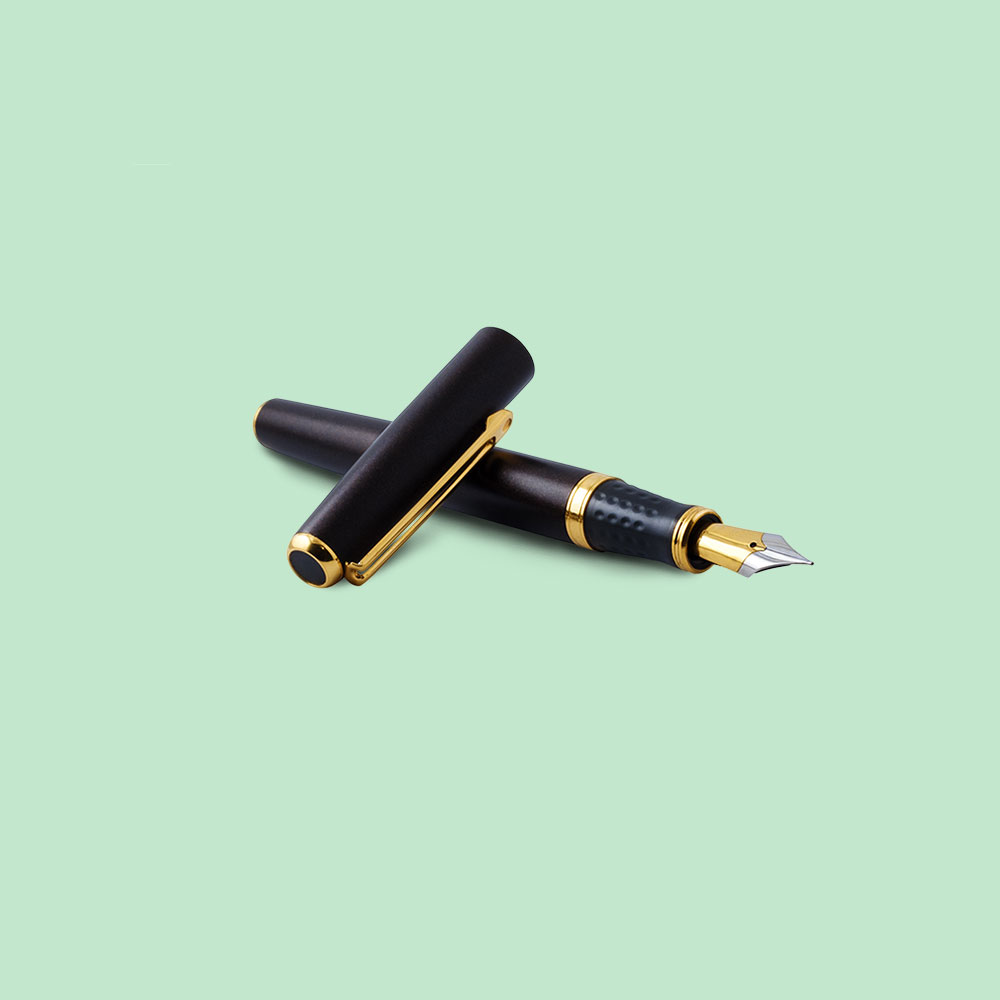 Black fountain pen with gold decorative detailing on pale green background